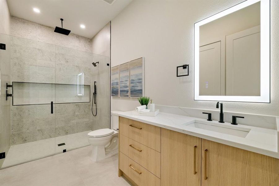 Bathroom featuring walk in shower, vanity, toilet, and tile patterned flooring