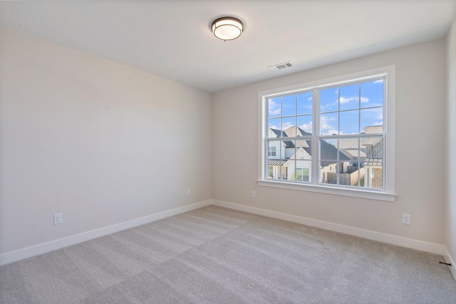 Spare room with baseboards and light carpet Spare room with baseboards and light carpet