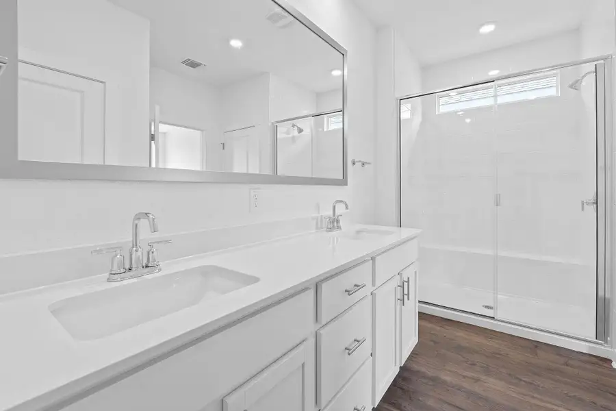 Full bathroom with a stall shower, double vanity, dark wood-style floors, and recessed lighting Full bathroom with a stall shower, double vanity, dark wood-style floors, and recessed lighting