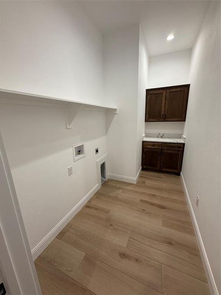 Washroom featuring light wood-style flooring, electric dryer hookup, and washer hookup Washroom featuring light wood-style flooring, electric dryer hookup, and washer hookup