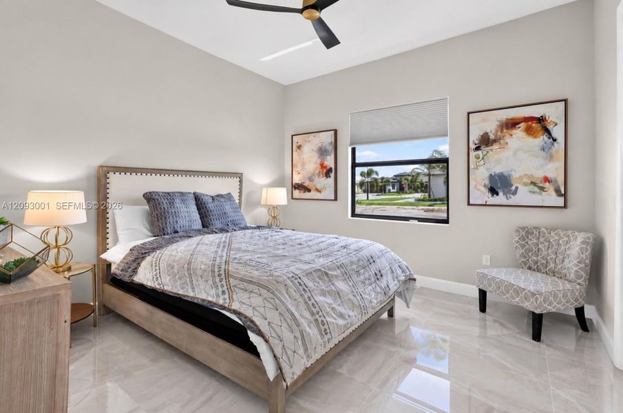 High ceilings featuring a matte black ceiling fan, neutral wall tones, large-format tile flooring, and a window with a roller shade High ceilings featuring a matte black ceiling fan, neutral wall tones, large-format tile flooring, and a window with a roller shade
