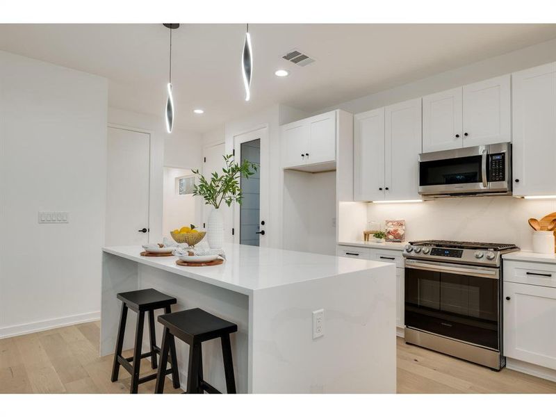 Center your culinary adventures around the stunning white quartz waterfall kitchen island creating a focal point that is both visually striking and immensely practical.