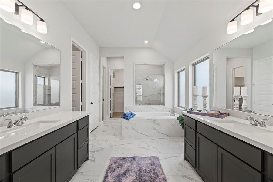 Spa-like primary bathroom features two vanities, soaking tub, separate shower and 2 walk-in closets.