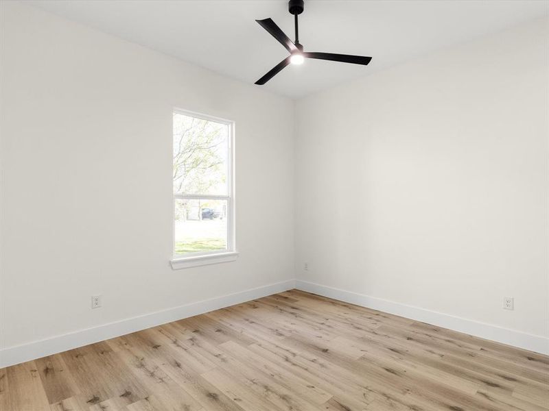 Empty room featuring light wood-type flooring and a ceiling fan