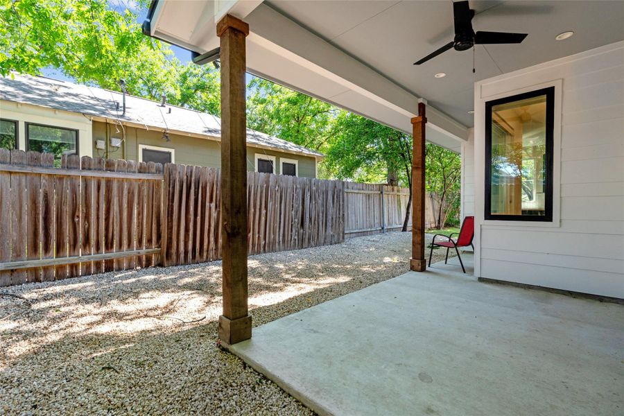 Covered patio featuring a concrete surface, exposed wood structural columns, a ceiling fan and fully fenced for privacy Covered patio featuring a concrete surface, exposed wood structural columns, a ceiling fan and fully fenced for privacy