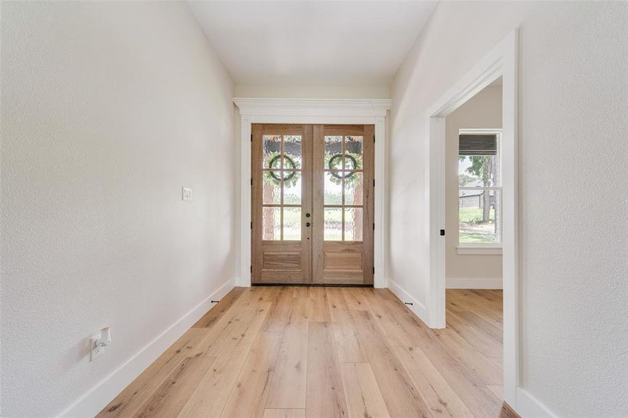 Double entry doors with glass panels and natural wood finish