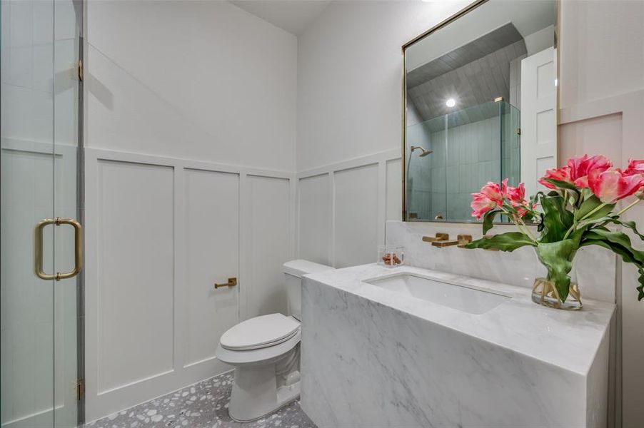 Bathroom featuring tile patterned flooring, vanity, walk in shower, and toilet