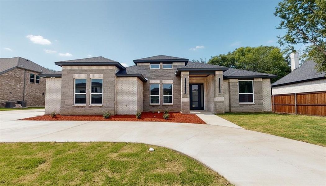 Prairie-style home with brick siding and a shingled roof
