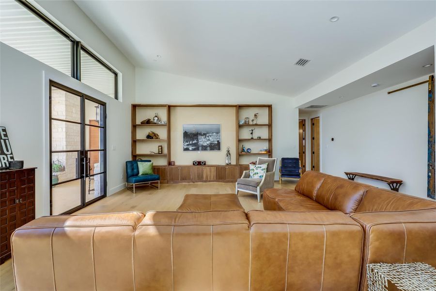 Living area with vaulted ceiling and light wood-style flooring
