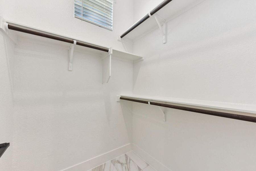 Walk in closet with marble look tile flooring