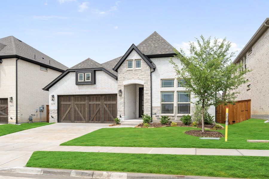 Stone and brick home with two-car garage, arched entry, and manicured front lawn Stone and brick home with two-car garage, arched entry, and manicured front lawn