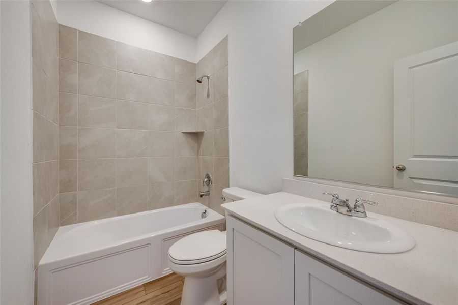 Full bathroom featuring tiled shower / bath, toilet, and vanity