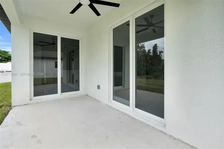 Lanai with ceiling fan and sliding glass doors.