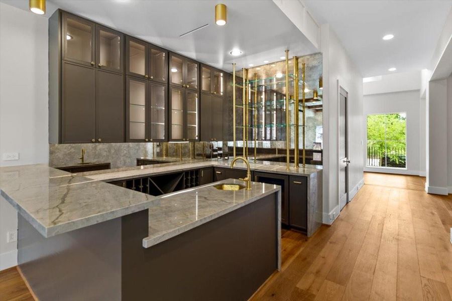 This is a bar!  Custom brass and glass shelves, antique mirror and glass LED lit cabinets