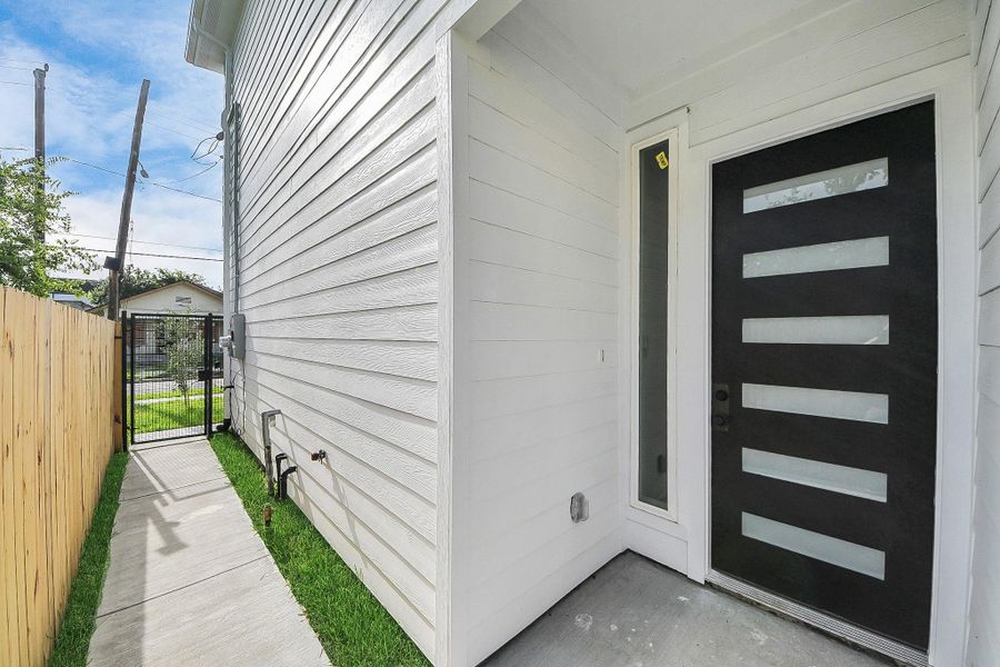 Modern front entry featuring a sleek contemporary door and gated access, offering added privacy and a secure, stylish first impression.