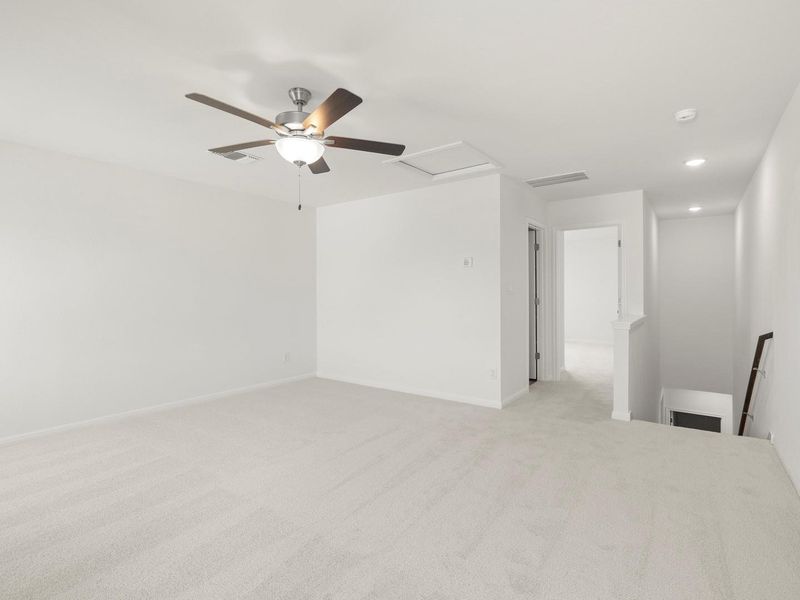 A spacious room offers comfortable carpeted flooring and efficient recessed lighting.