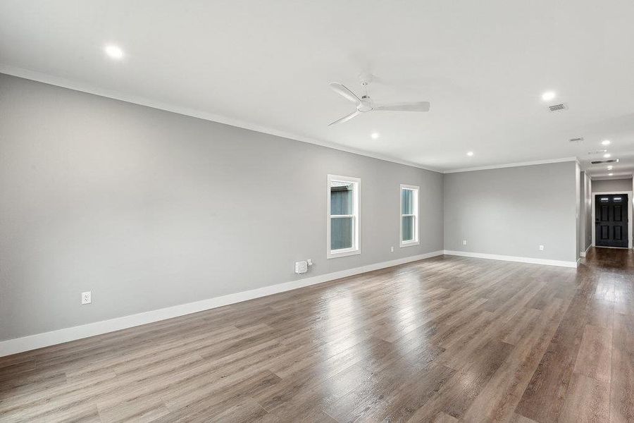 Empty room with crown molding, recessed lighting, light wood finished floors, and ceiling fan