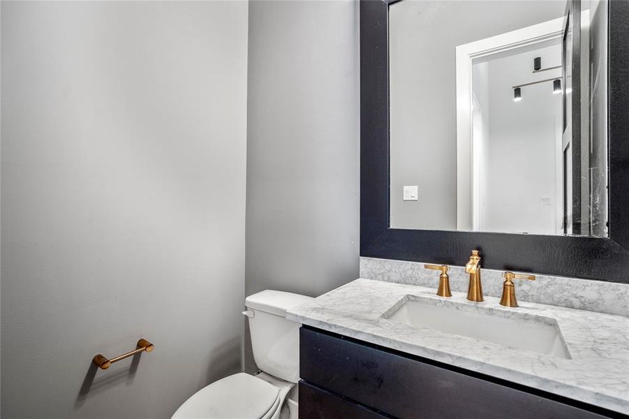 Stunning first-floor powder bath with custom designed countertops and hardware.