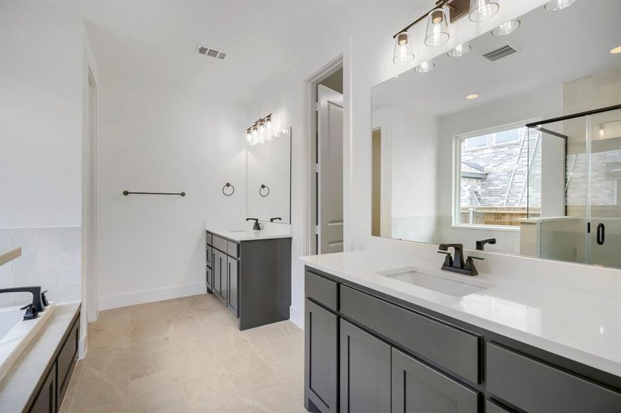 Dual vanity setup featuring white countertops and dark cabinetry, complemented by matte black fixtures Dual vanity setup featuring white countertops and dark cabinetry, complemented by matte black fixtures