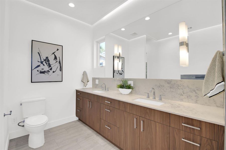 Full bathroom featuring double vanity, backsplash, recessed lighting, and light wood finished floors
