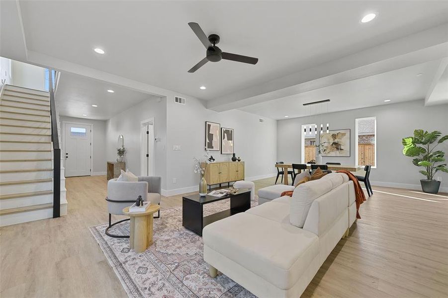 Living room with ceiling fan and light hardwood / wood-style floors