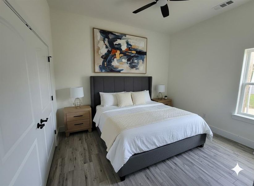 This room features light-colored walls, a ceiling fan, and a window providing natural light