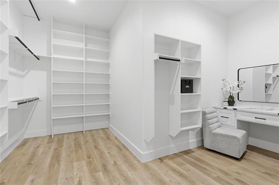 Walk in closet with light wood-style floors