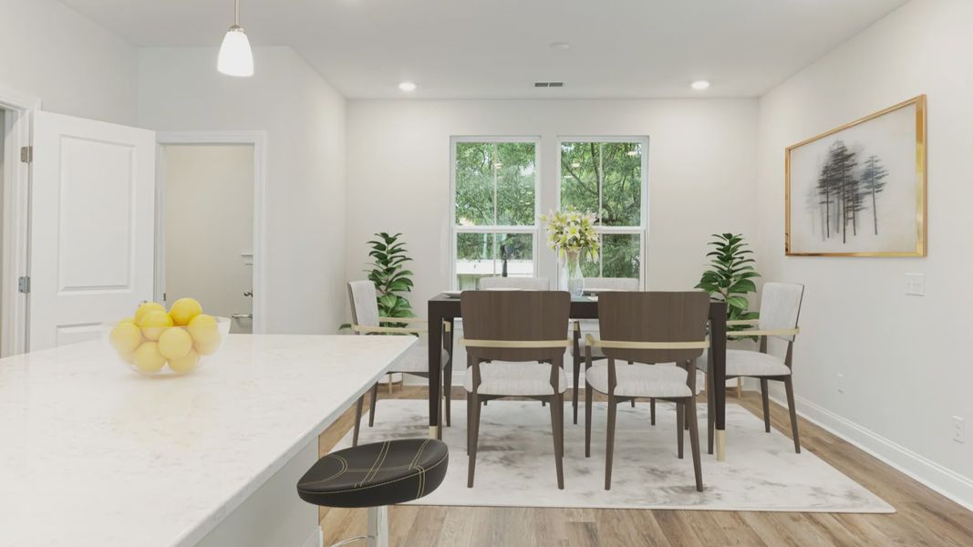 Island kitchen & dining area with 2 large windows in a DRB Homes Brookgreen model home