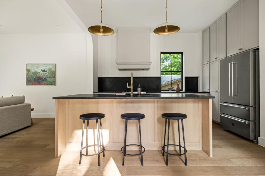 A well-lit kitchen presents a spacious island with ample seating, featuring integrated cabinetry and a modern appliance suite.