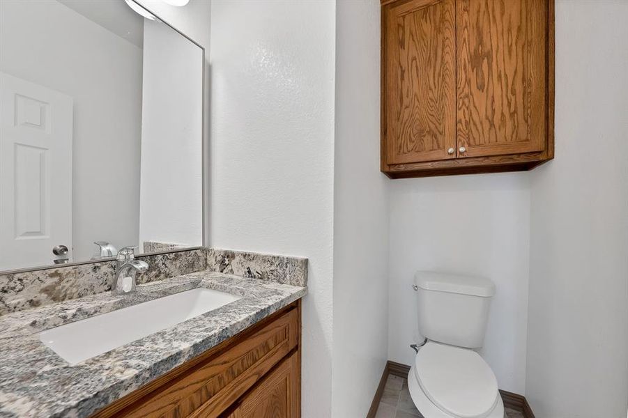 Half bathroom featuring vanity and toilet