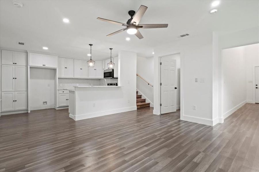 Unfurnished living room with ceiling fan and dark hardwood / wood-style floors