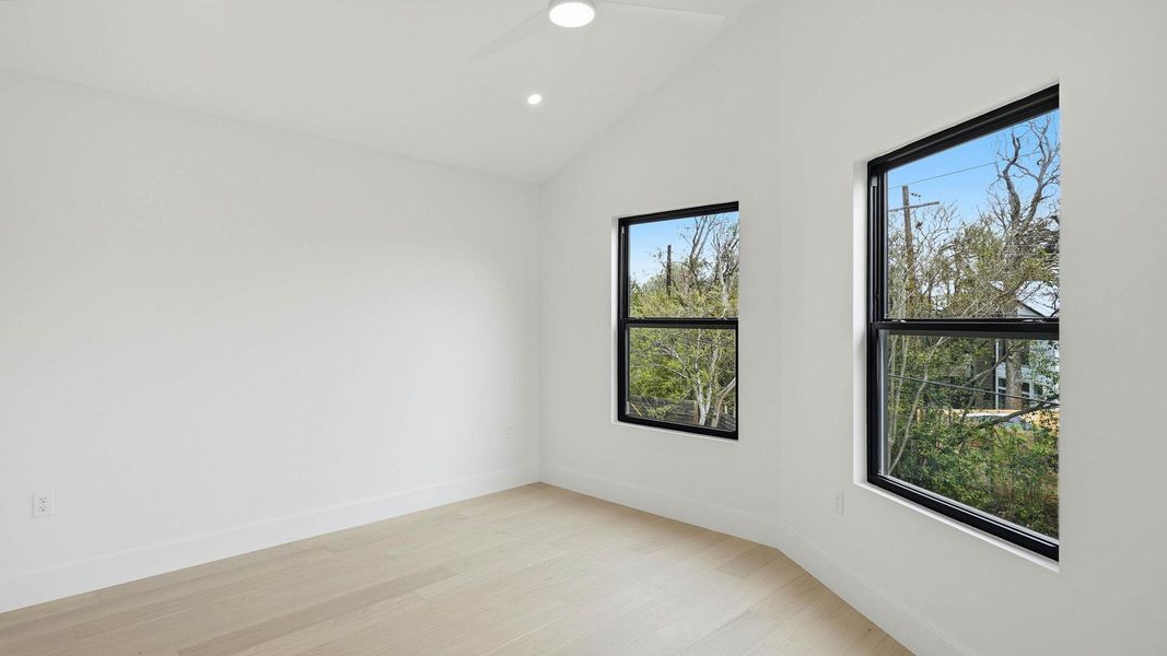 Spare room with light wood-style floors, recessed lighting, and lofted ceiling