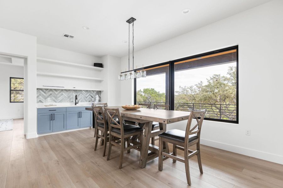 Dining room with light wood finished floors and recessed lighting