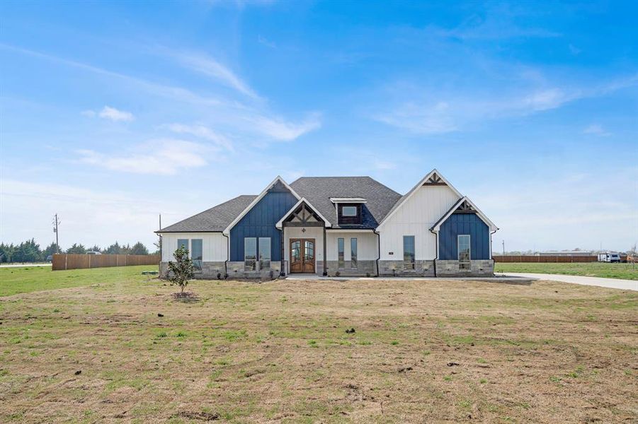 Modern inspired farmhouse featuring a front lawn