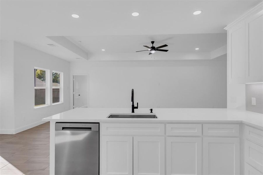 Kitchen with quartz countertops, stainless steel appliances, white cabinetry, a peninsula, and recessed lighting