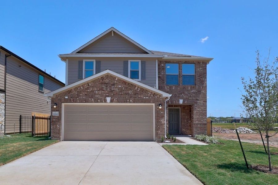Front exterior of a new home in Stoney Chase, Del Valle, TX, highlighting curb appeal (Image 1). Front exterior of a new home in Stoney Chase, Del Valle, TX, highlighting curb appeal (Image 1).