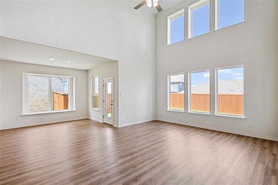 Unfurnished living room with ceiling fan, hardwood / wood-style flooring, and a wealth of natural light