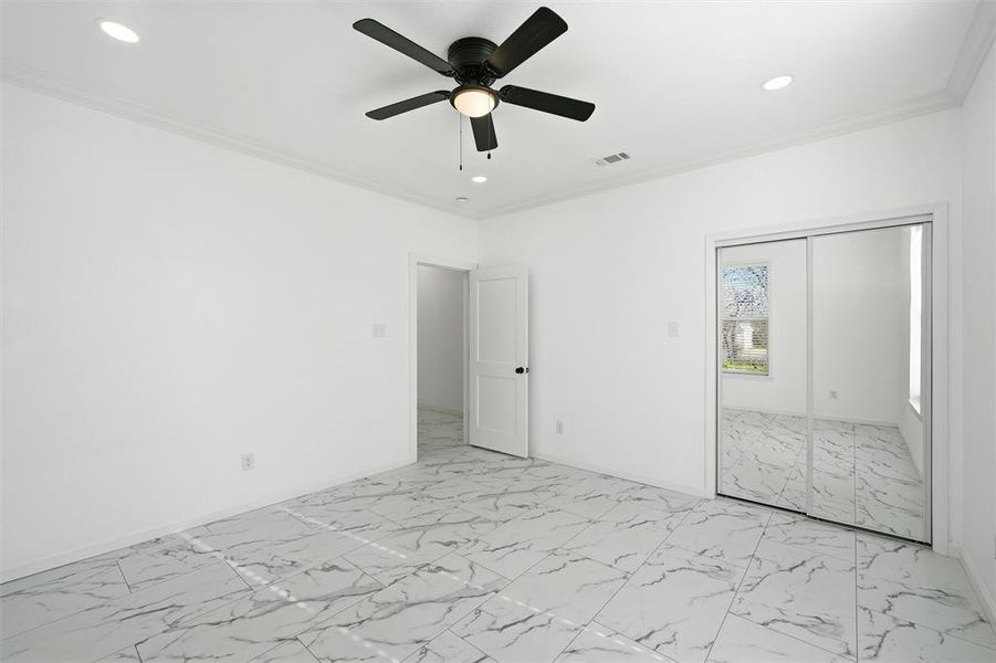Unfurnished bedroom featuring light marble finish floors, crown molding, a ceiling fan, a closet, and recessed lighting Unfurnished bedroom featuring light marble finish floors, crown molding, a ceiling fan, a closet, and recessed lighting