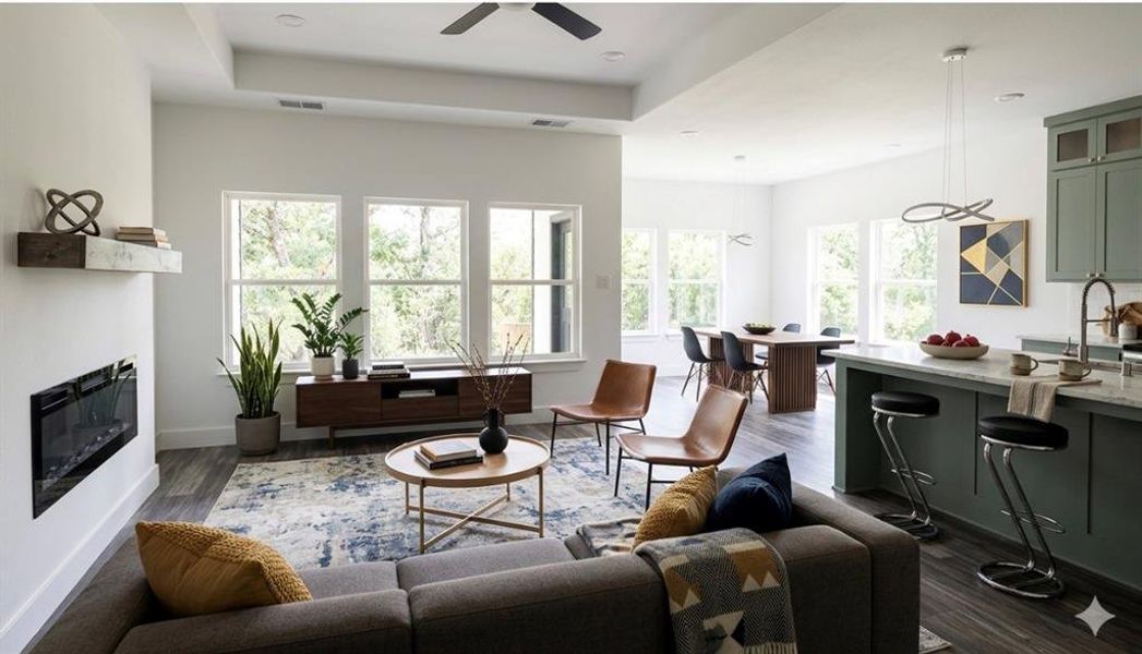 Open concept living area featuring wood-finish flooring, a contemporary electric fireplace with a floating mantel, and multiple large windows