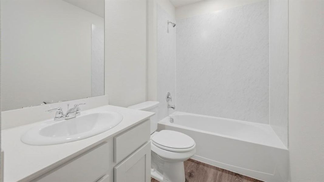 Full bathroom featuring vanity,  shower combination, and light wood-style flooring