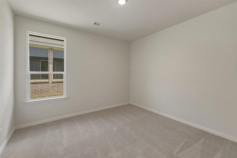 Carpeted interior space featuring a single window with white trim, light-colored walls, white baseboards, and a recessed ceiling light Carpeted interior space featuring a single window with white trim, light-colored walls, white baseboards, and a recessed ceiling light