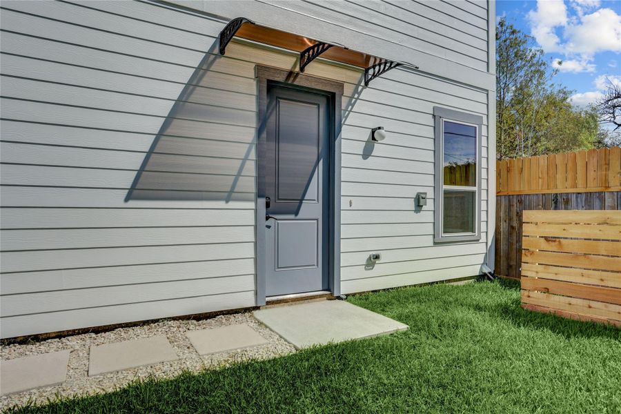 The home has a covered front entry and solid wood front door.