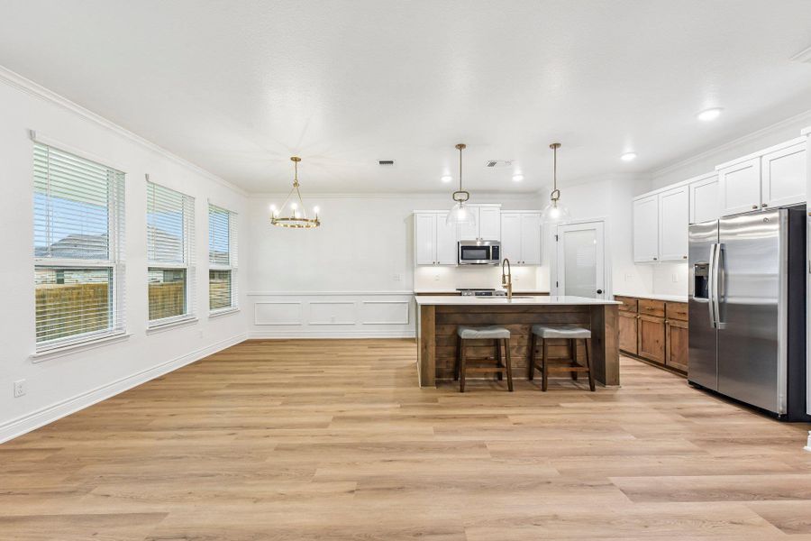 A seamless blend of kitchen and dining area, featuring a central island and abundant natural light. A seamless blend of kitchen and dining area, featuring a central island and abundant natural light.