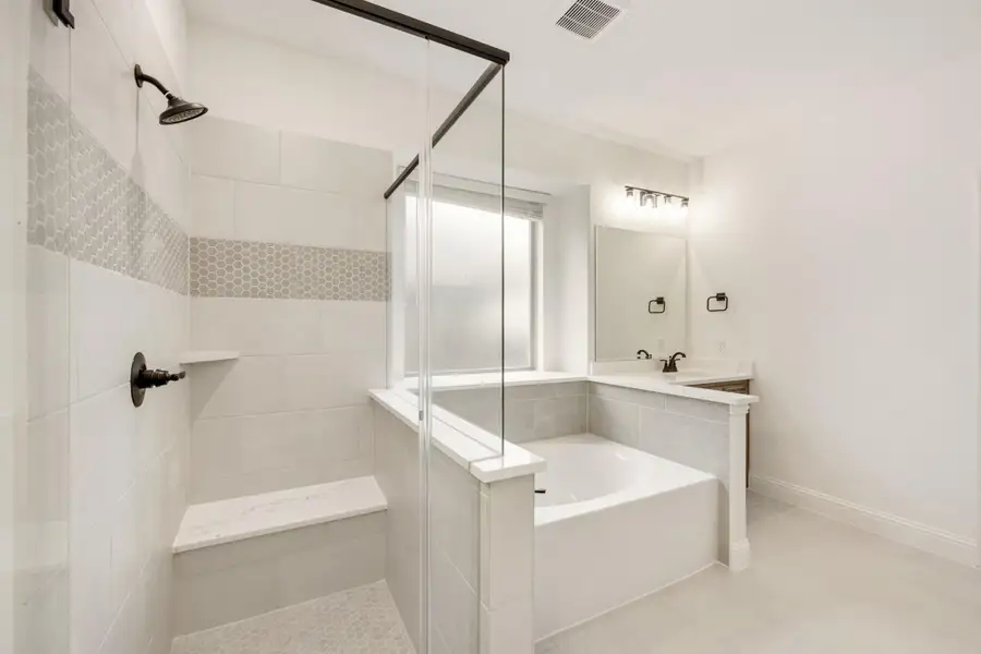 Bathroom with glass walk-in shower, soaking tub, and single vanity with white tile walls Bathroom with glass walk-in shower, soaking tub, and single vanity with white tile walls
