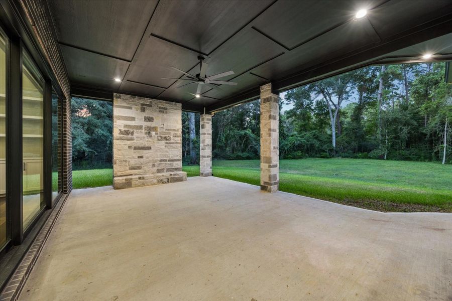 Seamlessly extending the home's living spaces outdoors, the expansive covered patio was designed for year-round entertaining. Prewired for an outdoor television and surrounded by peaceful wooded views, it creates the perfect setting for relaxed gatherings.