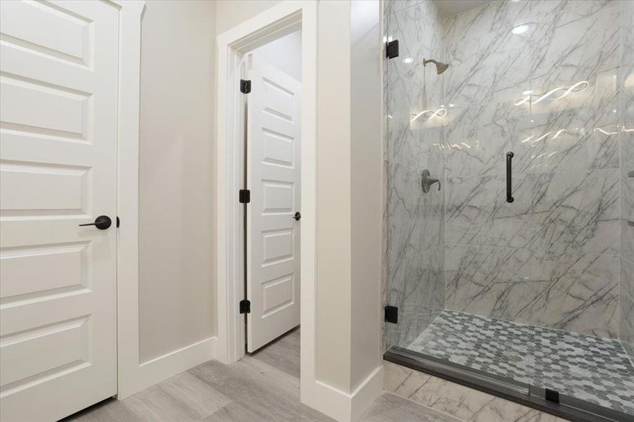 Bathroom featuring a shower with door and hardwood / wood-style flooring