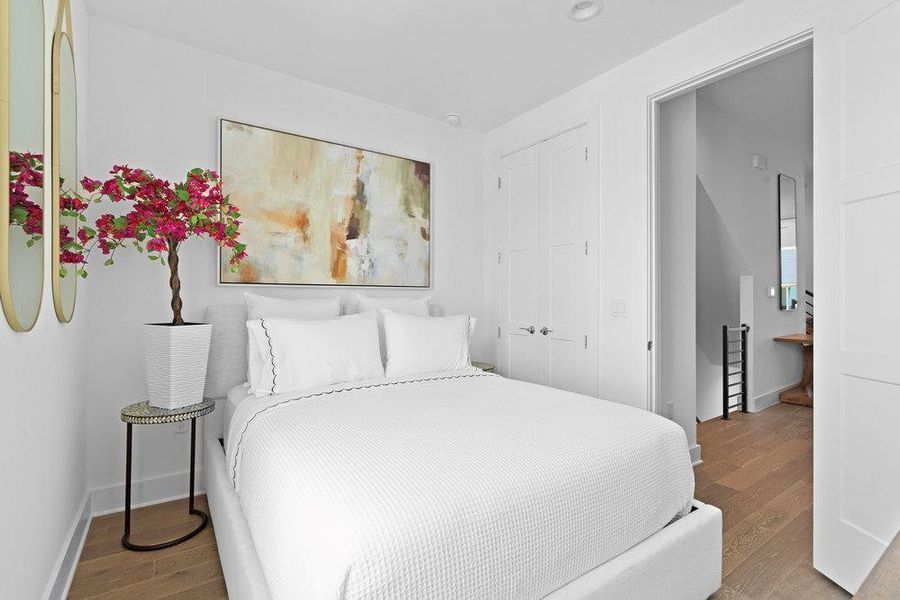 Bedroom with wood finished floors and a closet