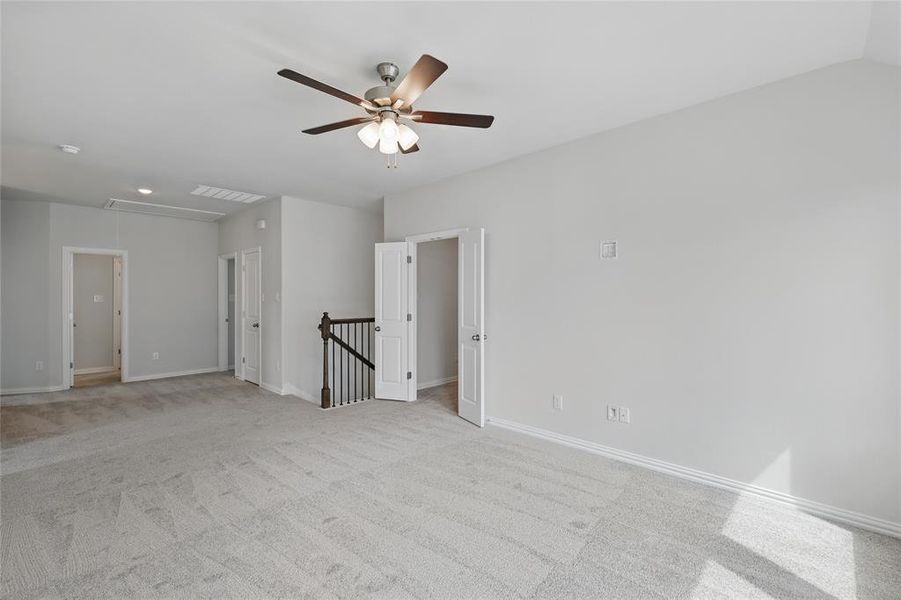 Unfurnished room with visible vents, baseboards, attic access, light carpet, and a ceiling fan Unfurnished room with visible vents, baseboards, attic access, light carpet, and a ceiling fan