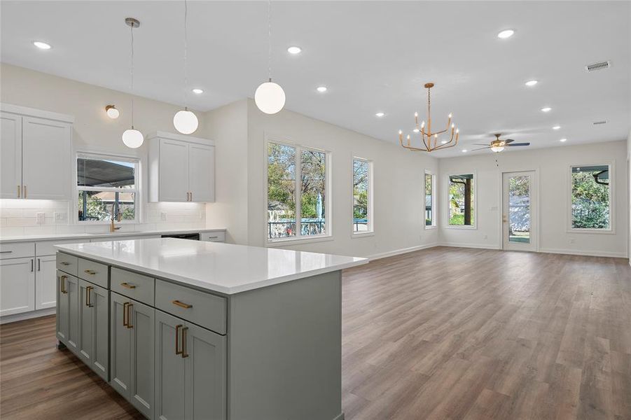 Kitchen featuring pendant lighting, a kitchen island, recessed lighting, dark wood-type flooring, and a ceiling fan Kitchen featuring pendant lighting, a kitchen island, recessed lighting, dark wood-type flooring, and a ceiling fan