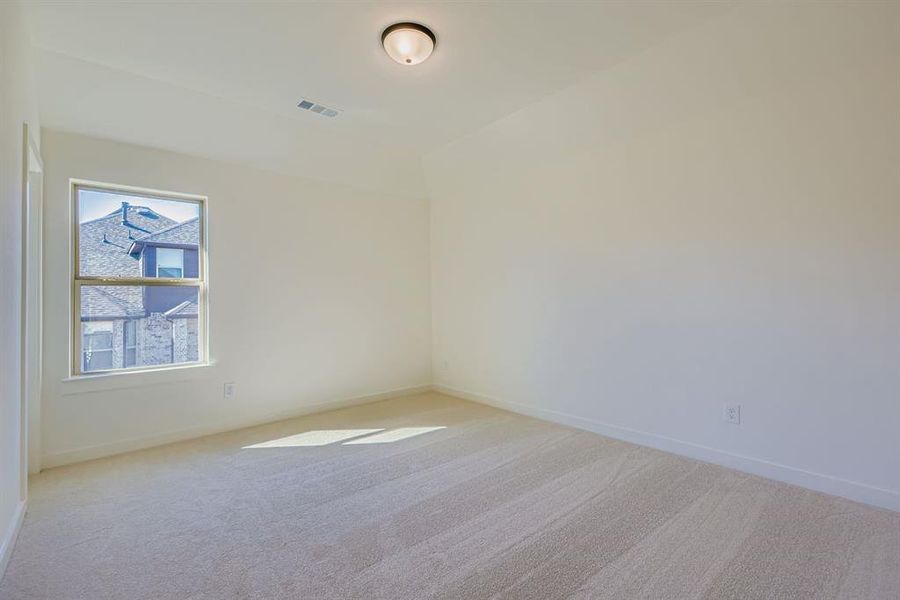 Empty room featuring light colored carpet and baseboards
